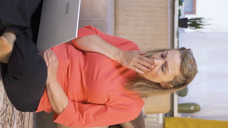 Vertical-video-of-Woman-looking-at-laptop-in-amazement.